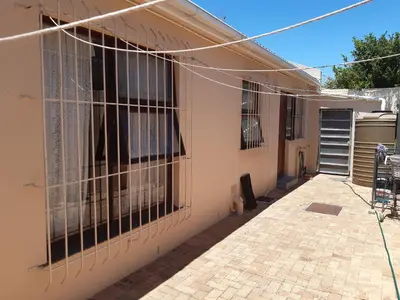 a house with barred windows on the side of it at Cosy studio garden cottage in Cape Town