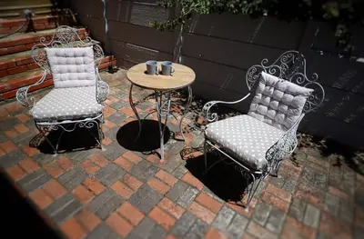 two chairs and a table with two cups on a patio at At Hummingbird Hill Hermanus in Hermanus