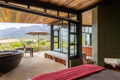 a bedroom with a bath tub and a table with a table at Steenbok farm cottages Sunbird Cottage in Wolseley