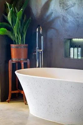 a white bath tub with a faucet in a bathroom at Steenbok farm cottages Sunbird Cottage in Wolseley