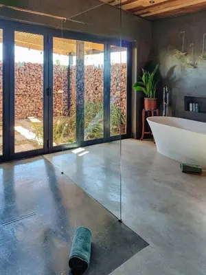 a bathroom with a bath tub and a bath board on the floor at Steenbok farm cottages Sunbird Cottage in Wolseley