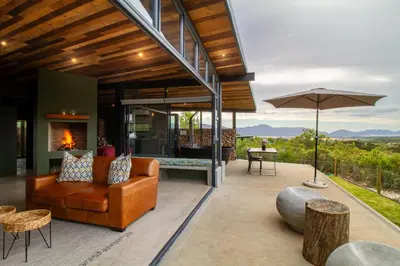 an outdoor living room with a couch and an umbrella at Steenbok farm cottages Sunbird Cottage in Wolseley