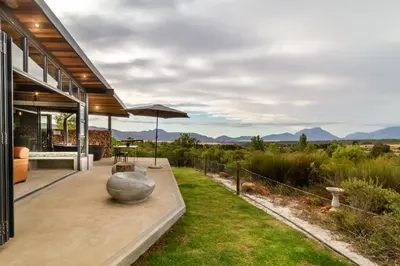 an outdoor patio with a table and an umbrella at Steenbok farm cottages Sunbird Cottage in Wolseley