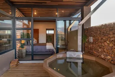 a room with a bath tub and a bedroom at Steenbok farm cottages Kingfisher Cottage in Wolseley