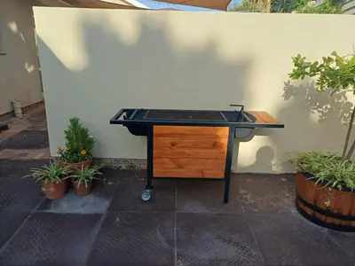 a black desk against a wall with plants at Strandloper Room in Cape Town