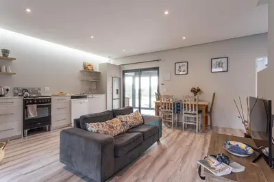 a living room with a couch and a kitchen at Prinia on Peak holiday home in Pringle Bay
