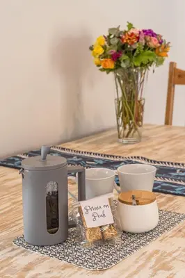 a table with a candle and flowers and a vase of flowers at Prinia on Peak holiday home in Pringle Bay