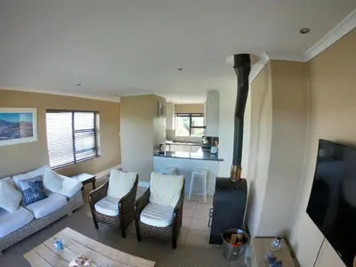 a living room with a couch and chairs and a stove at Blue Mountain View in Cape Town