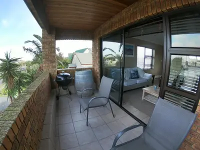 a balcony with chairs and a couch on a patio at Blue Mountain View in Cape Town