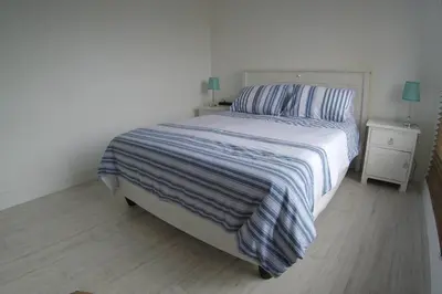 a bedroom with a bed with a striped comforter at Blue Mountain View in Cape Town