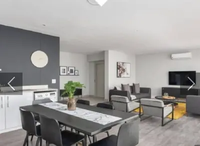 a living room with a black table and chairs at Franschhoek - La Petit Village - Views in Franschhoek