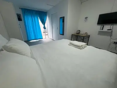 a white bedroom with a large white bed and a window at No 1 Guest house in Cape Town