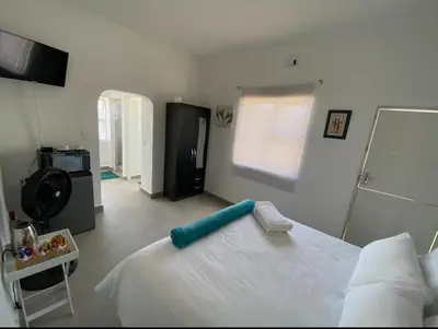 a bedroom with a white bed with a blue headboard at No 1 Guest house in Cape Town
