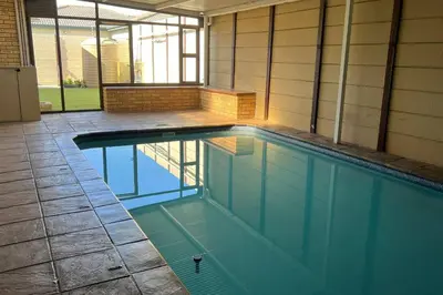 a swimming pool with blue water in a house at Bosch Villa in Cape Town