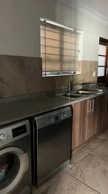 a kitchen with a washing machine and a sink at Bosch Villa in Cape Town