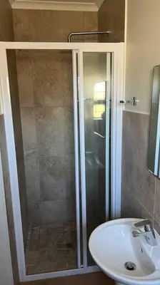 a bathroom with a shower and a sink at Bosch Villa in Cape Town