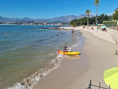 a person in a yellow boat on the beach at 'Seagul Cove', Private Villa on the beach, Sleeps 7 in Cape Town