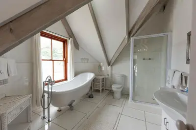 a bathroom with a tub and a shower and a sink at 'Seagul Cove', Private Villa on the beach, Sleeps 7 in Cape Town