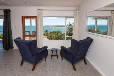 two chairs in a living room with a view of the ocean at 'Seaside Cottage', Sleeps 4 with a 3 minute walk from the beach! in Cape Town