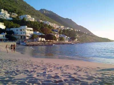 a couple of people walking on the beach at 'Seaside Cottage', Sleeps 4 with a 3 minute walk from the beach! in Cape Town