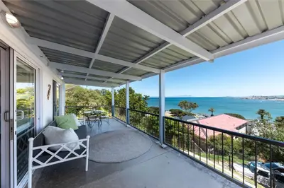 a balcony with a view of the ocean at 'Seaside Cottage', Sleeps 4 with a 3 minute walk from the beach! in Cape Town