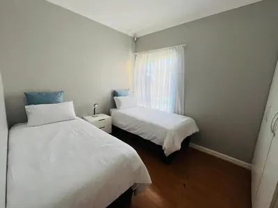 a bedroom with two beds and a window at 4 Bedroom Bliss in Cape Town