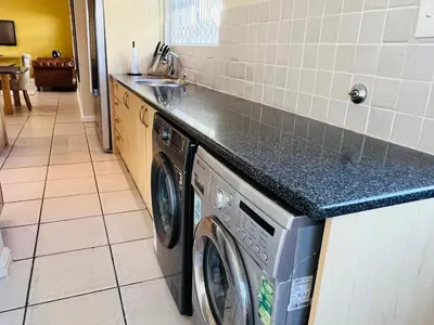 a kitchen with a washing machine and a counter at 4 Bedroom Bliss in Cape Town