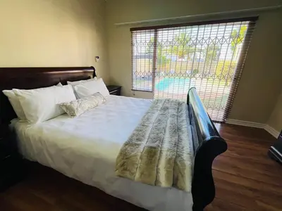 a bed in a bedroom with a large window at 4 Bedroom Bliss in Cape Town