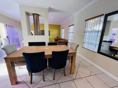 a dining room with a wooden table and chairs at 4 Bedroom Bliss in Cape Town