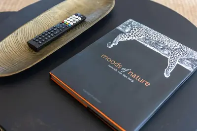 a book with a remote control sitting on top of it at Cosy Home in Claremont in Cape Town