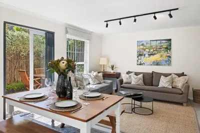 a living room with a table and a couch at Cosy Home in Claremont in Cape Town