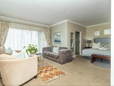 a living room with a bed and a couch at Hermanus Cliff Path Lodge - No Load-shedding in Hermanus