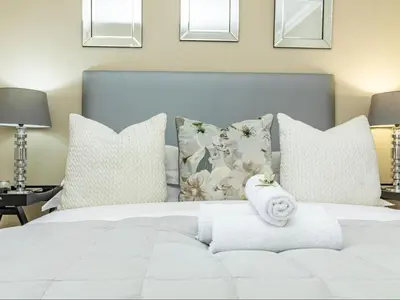 a white bed with pillows and a towel at Hermanus Cliff Path Lodge - No Load-shedding in Hermanus