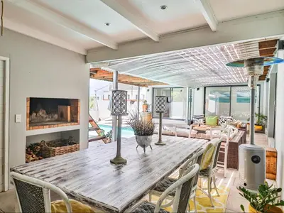 a dining room with a wooden table and chairs at Hermanus Cliff Path Lodge - No Load-shedding in Hermanus