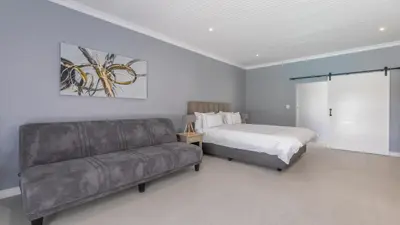 a bedroom with a bed and a couch at Inkantu Apartments & Suites in Cape Town