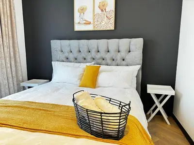 a bedroom with a large bed with a basket on it at S.A.E. Nine Palms Luxury in Cape Town