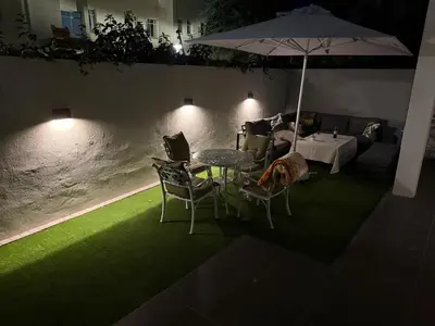 a table and chairs with an umbrella and a dog under it at La Gratitude 8 luxury in Stellenbosch CENTRAL in Stellenbosch