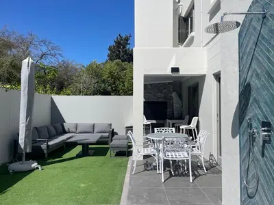 a patio with a couch and a table and chairs at La Gratitude 8 luxury in Stellenbosch CENTRAL in Stellenbosch