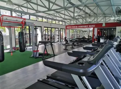 a gym with a row of treadmills and machines at The Sandown Blouberg self catering unit in Parklands