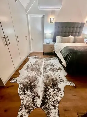 a bedroom with a bed and a rug on the floor at Ben's Apartment in Stellenbosch