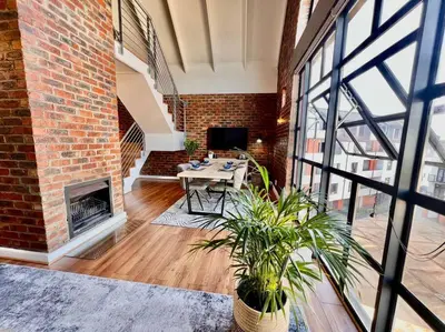 a brick room with a table and a fireplace at Ben's Apartment in Stellenbosch