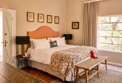 a bedroom with a bed with a teddy bear on it at Boschendal Farm Estate in Franschhoek