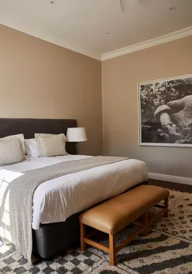 a bedroom with a large bed and a painting at Boschendal Farm Estate in Franschhoek