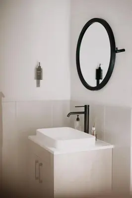 a white bathroom with a sink and a mirror at Springsteen Cabins in Rawsonville