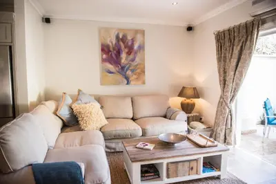 a living room with a couch and a table at Maison Des Huguenots Le Roux in Franschhoek