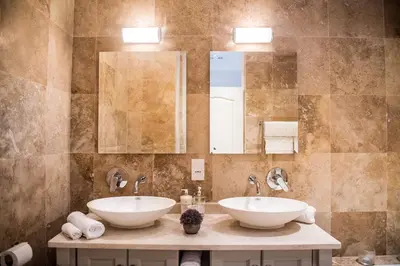 a bathroom with two sinks and a mirror at Maison Des Huguenots Le Roux in Franschhoek
