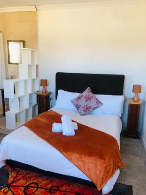 a bedroom with a bed with two towels on it at Bergsig Casa Guest House in Cape Town