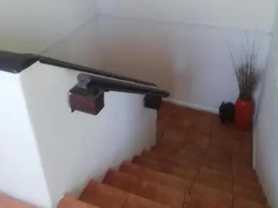 a stairway with a rail on the side of a wall at Bergsig Casa Guest House in Cape Town
