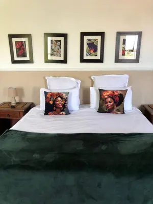 a bed with two pictures of two women on it at Bergsig Casa Guest House in Cape Town