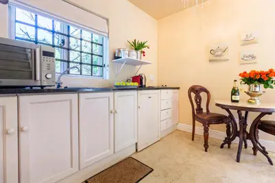 a kitchen with a table and a microwave at Devon Castle Orchard Cottage in Stellenbosch